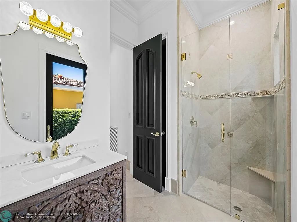 A bathroom with a sink , mirror , and walk in shower.