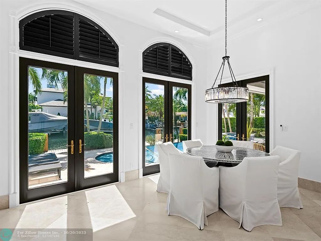 A dining room with a table and chairs and a chandelier.