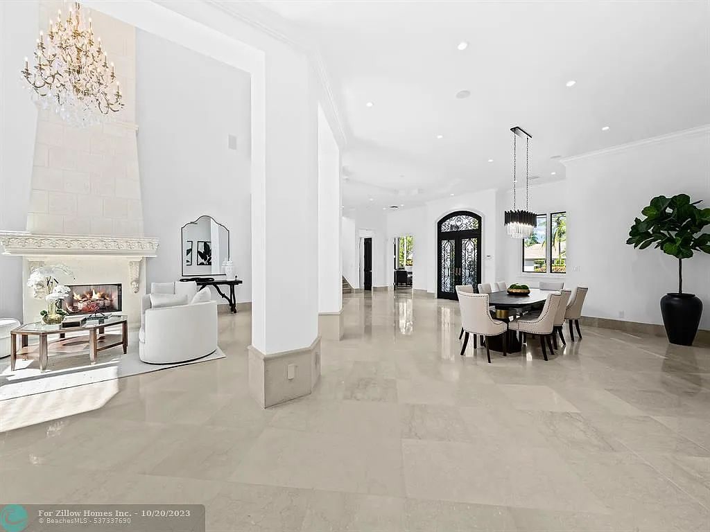 A living room with a fireplace and a dining room with a table and chairs.