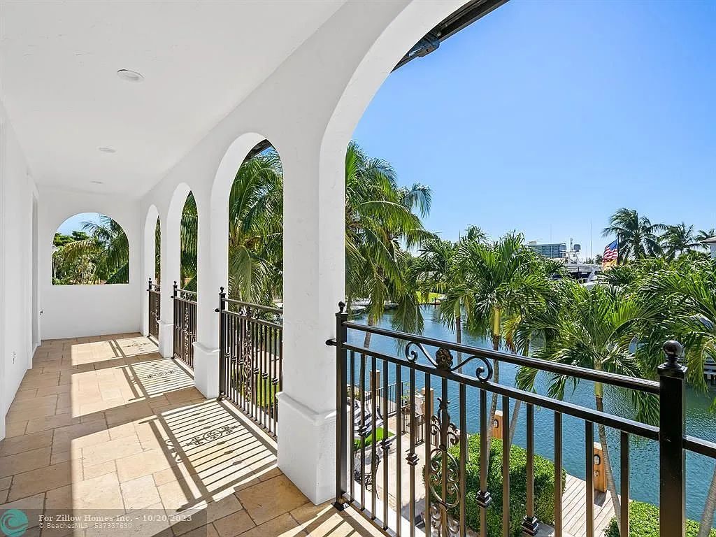 There is a balcony with a view of the water and trees.
