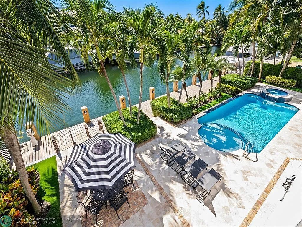 There is a large swimming pool in the backyard of a house.