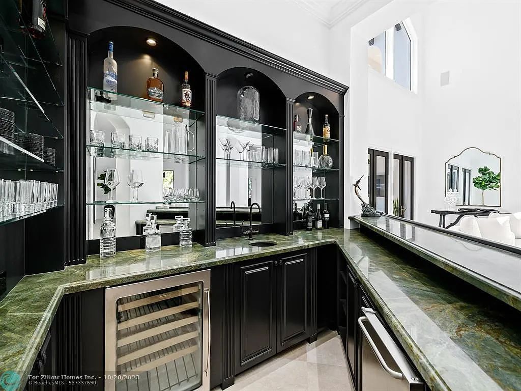 A kitchen with a bar and a wine cooler