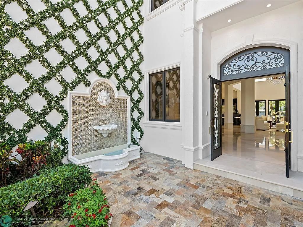 A large white house with a fountain in front of it.