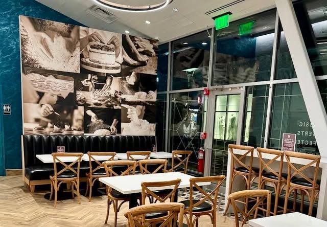 A restaurant with tables and chairs and a large mural on the wall.