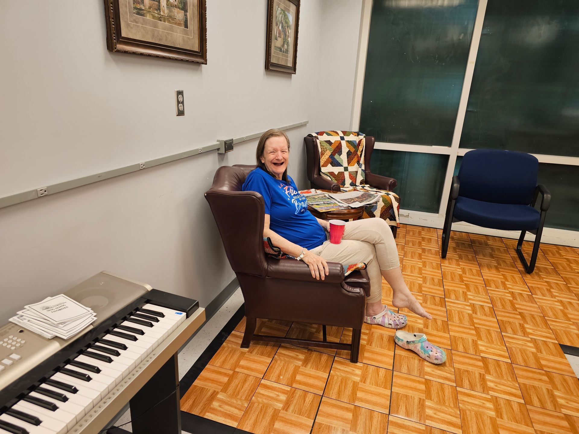 A woman is sitting in a chair next to a keyboard.