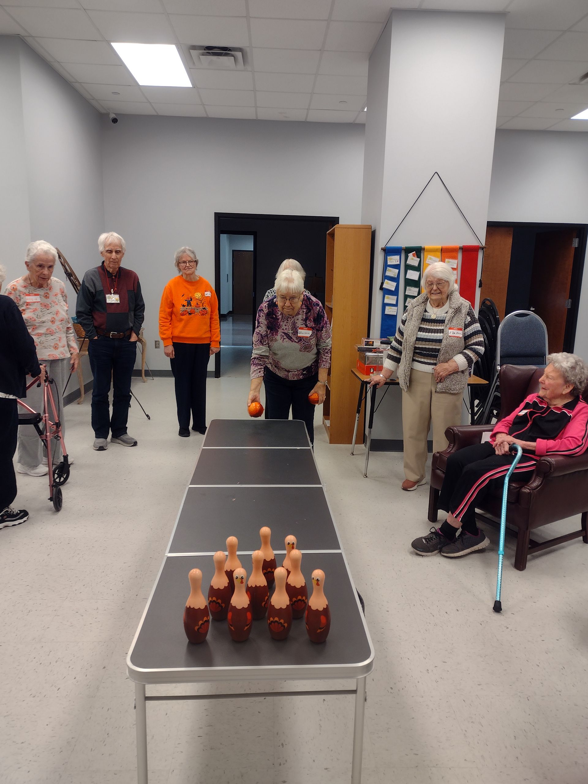 A group of elderly people are playing ping pong