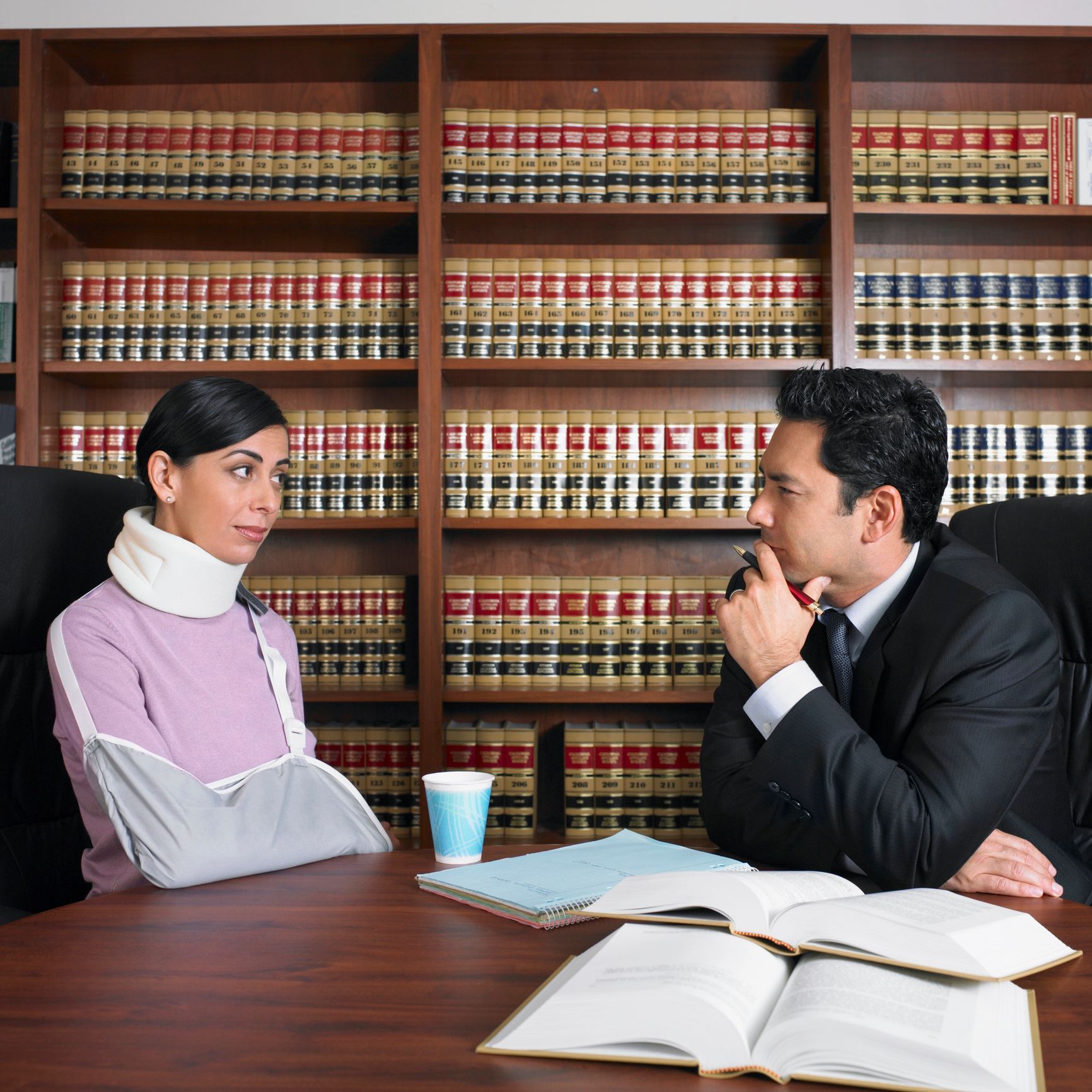 A man & woman discussing a case in a courtroom, representing a personal injury lawyer consultation.