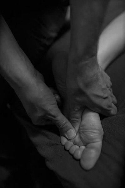 Close-up of hands gently holding a baby’s foot