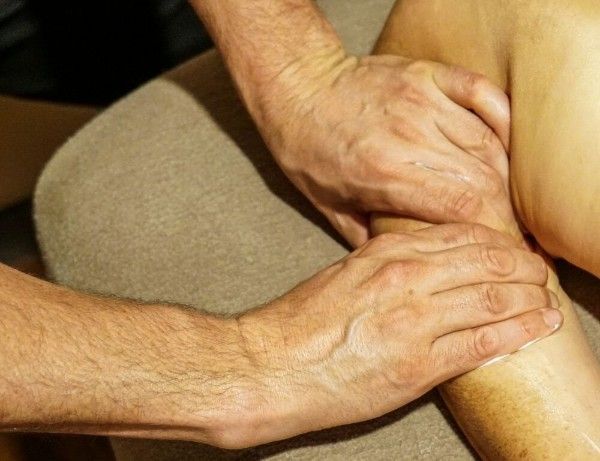 Hands massaging a person’s leg in a therapy setting
