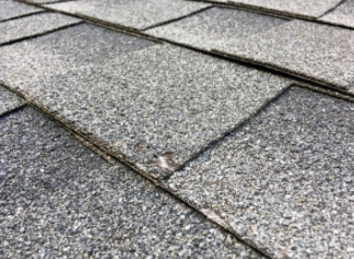 Close up picture asphalt shingle with damage from a hail storm that occurred in Cheyenne WY