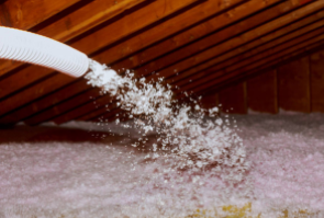 roofing technichian spraying fiberglass insulation with fiberglass machine in attic in Cheyenne WY