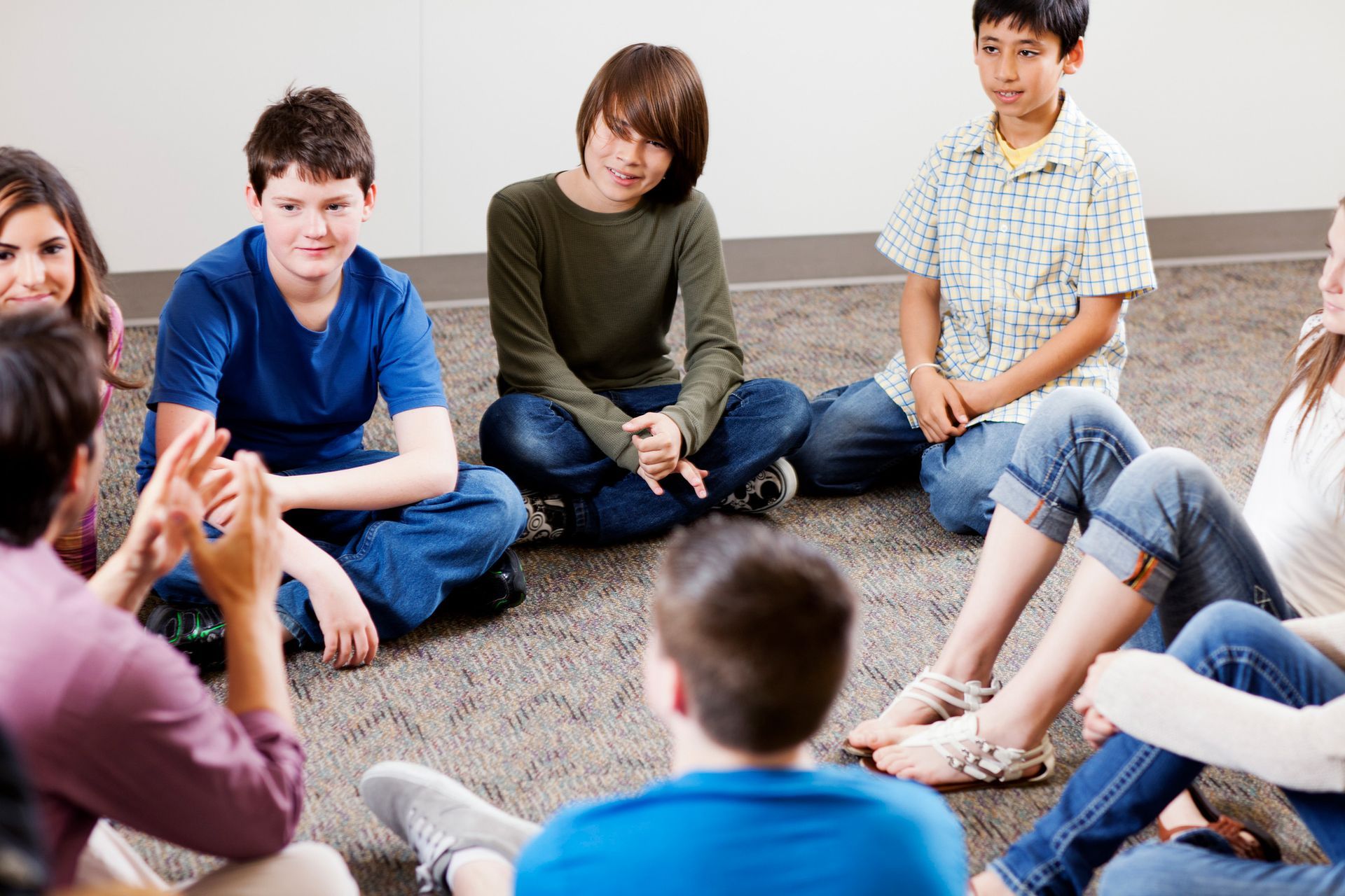 A group of children are sitting in a circle on the floor.