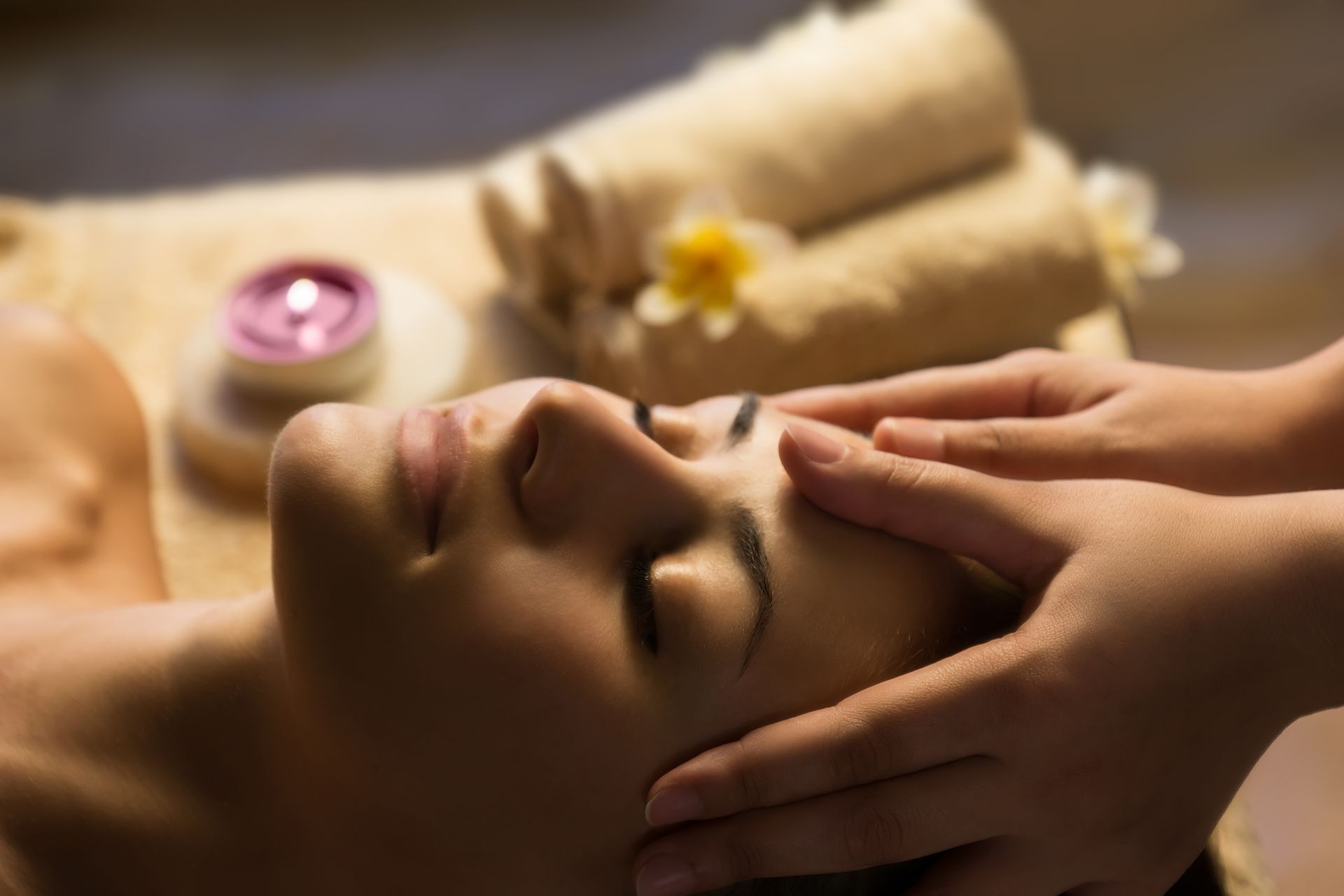 A woman is getting a head massage at a spa.