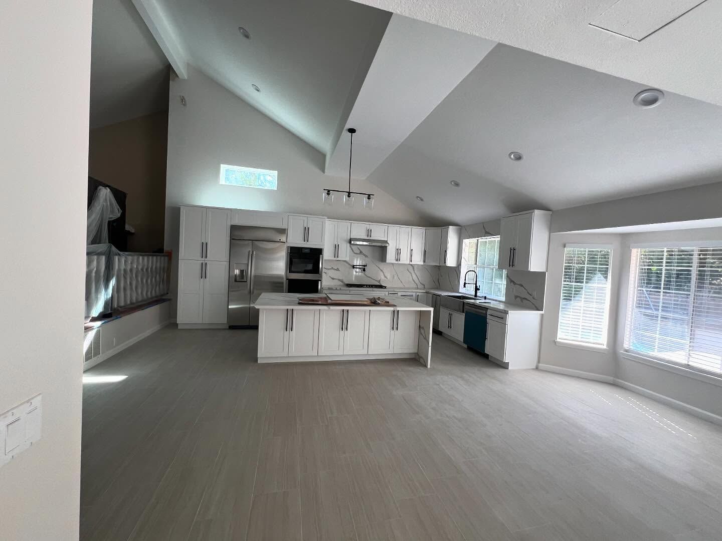Kitchen with light wood cabinets, stainless steel appliances, granite countertops, and wood floors.