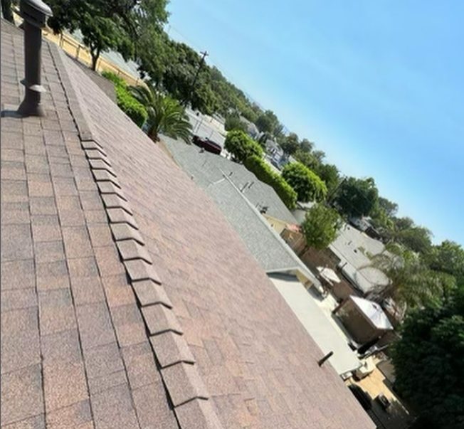 White truck towing a trailer with a Bobcat and excavator in a parking lot.