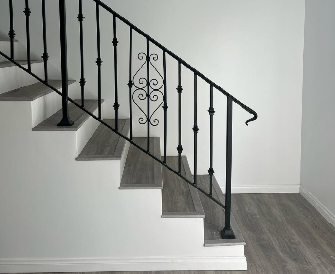 House under construction, wood framing with roof and tower, blue sky, green grass.