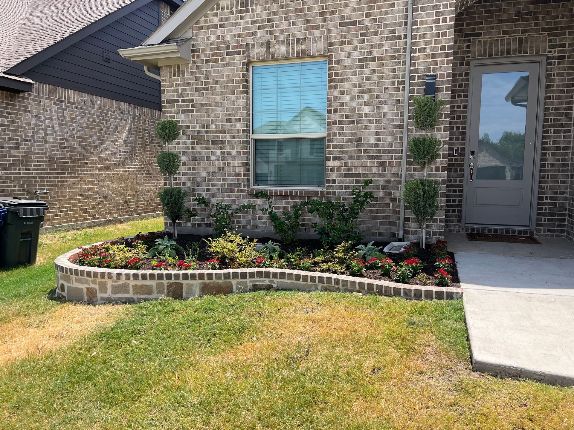 A brick house with a garden in front of it.