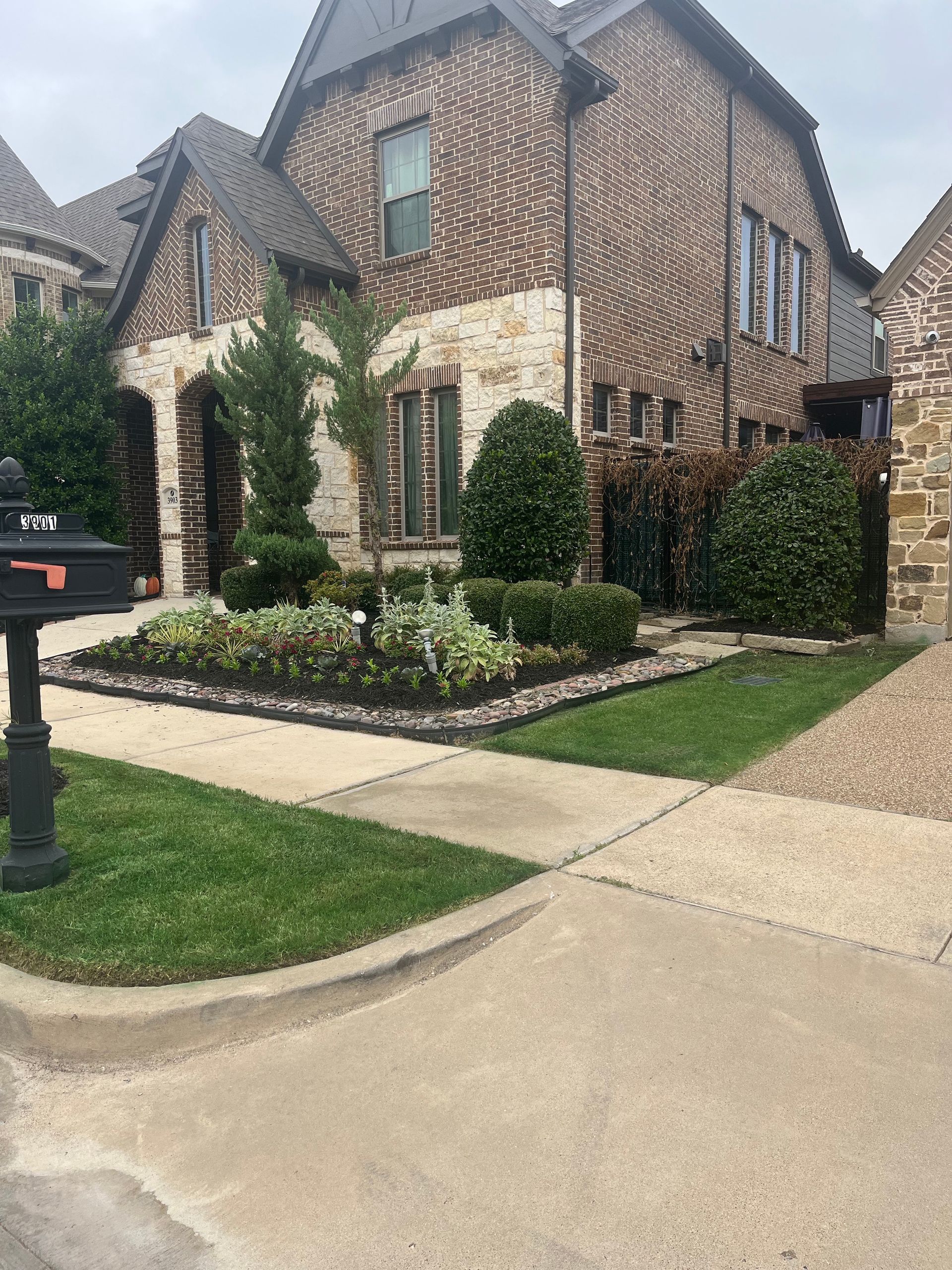 A large brick house with a mailbox in front of it.
