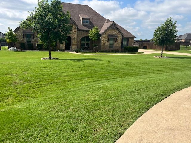 A large house with a lush green lawn in front of it.