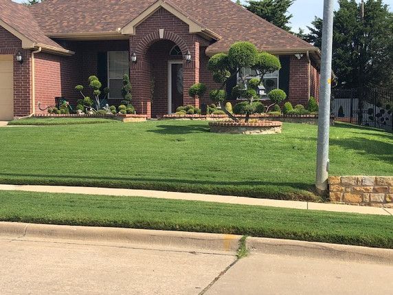 A brick house with a lush green lawn in front of it.