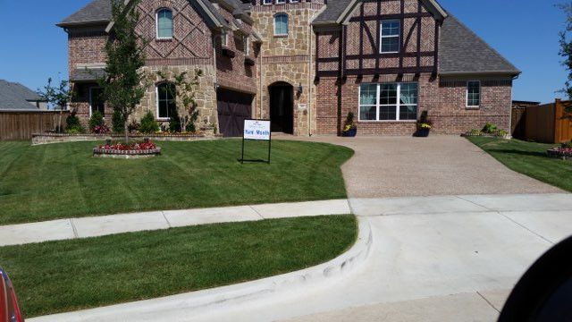 A large brick house with a for sale sign in front of it