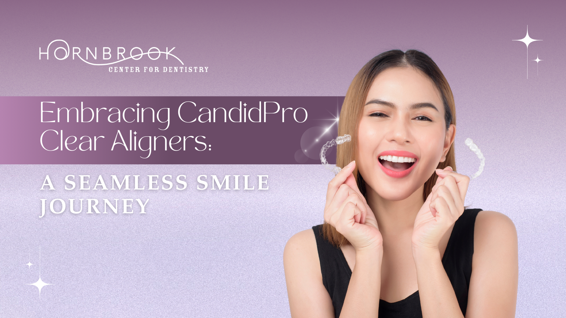 A woman is smiling with clear aligners on her teeth.