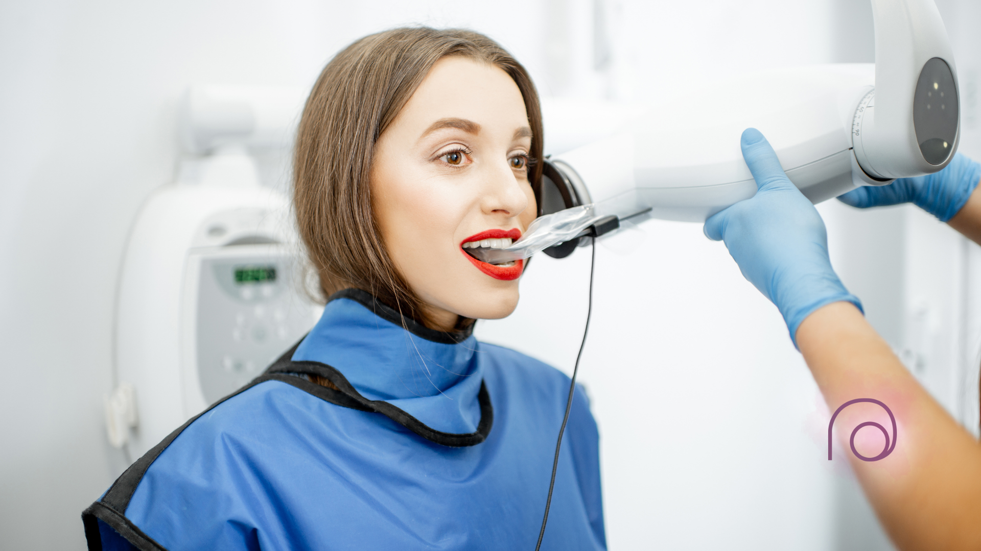 A woman is getting an x-ray of her teeth in a dental office.