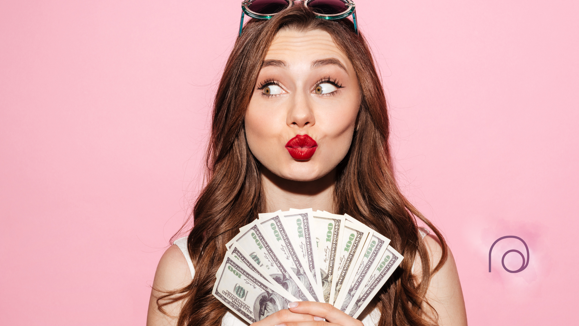 A woman is blowing a kiss while holding a fan of money.
