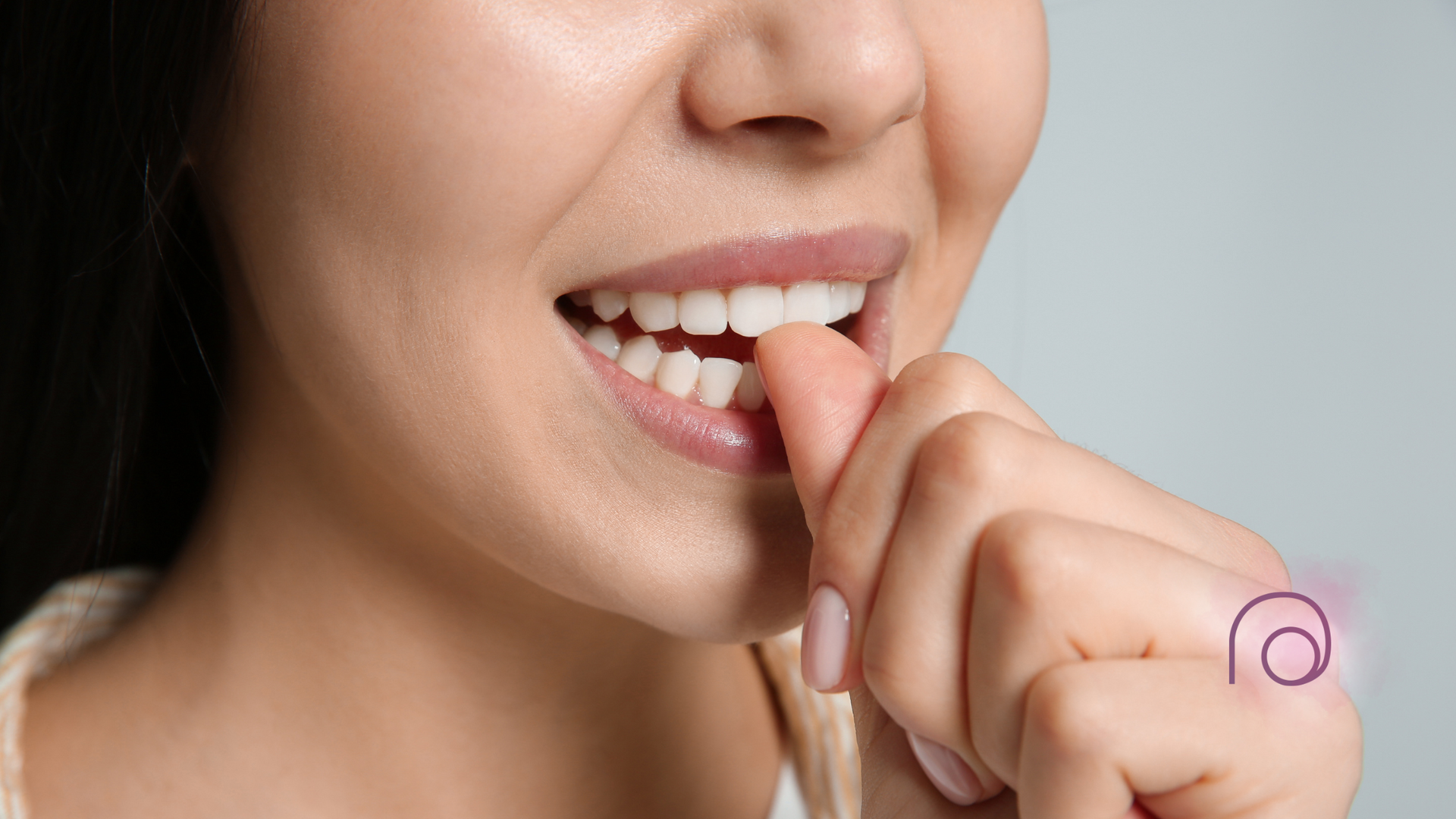 A close up of a woman biting her nails.