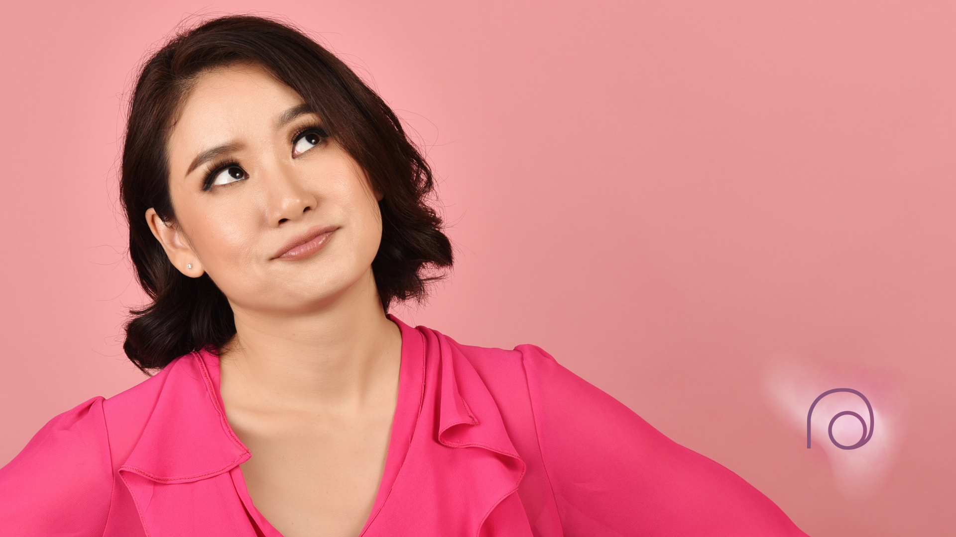 A woman in a pink shirt is looking up at the sky.