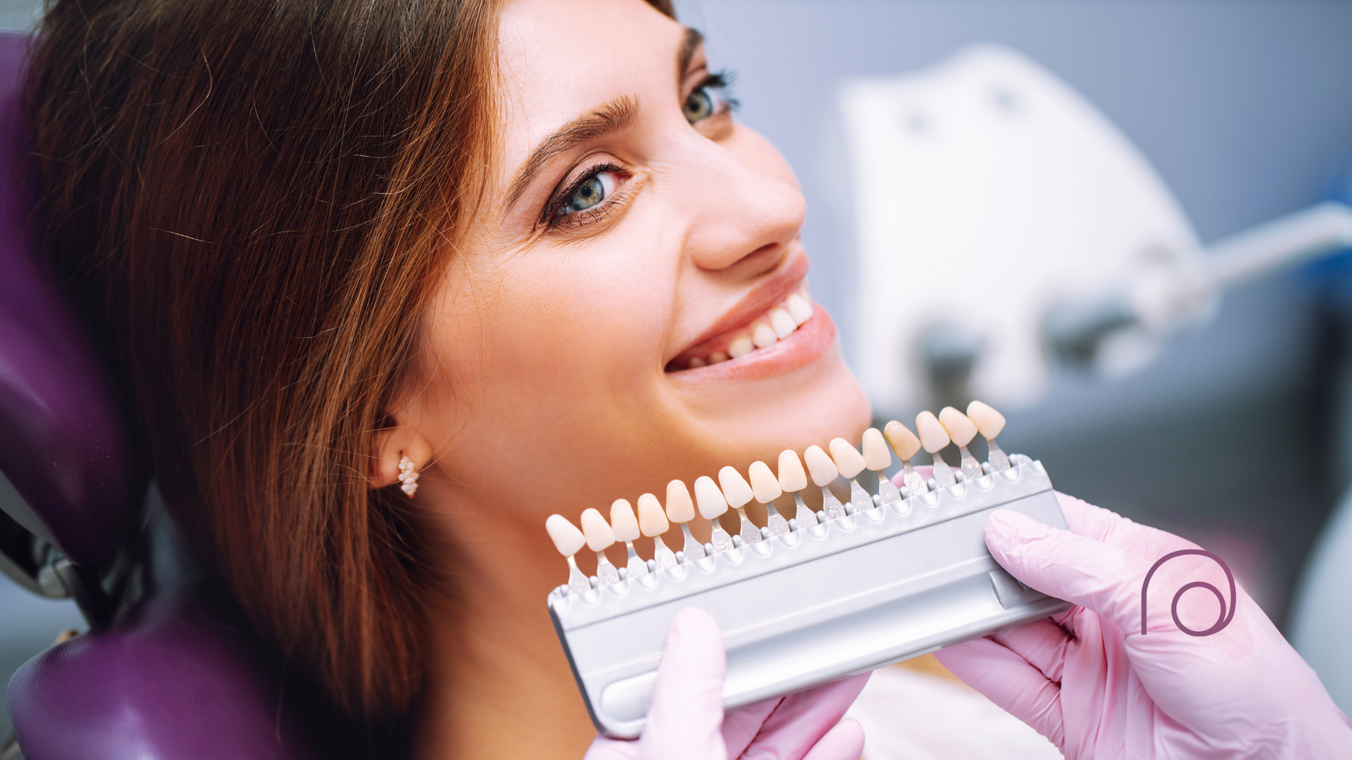 A woman is sitting in a dental chair while a dentist examines her teeth.