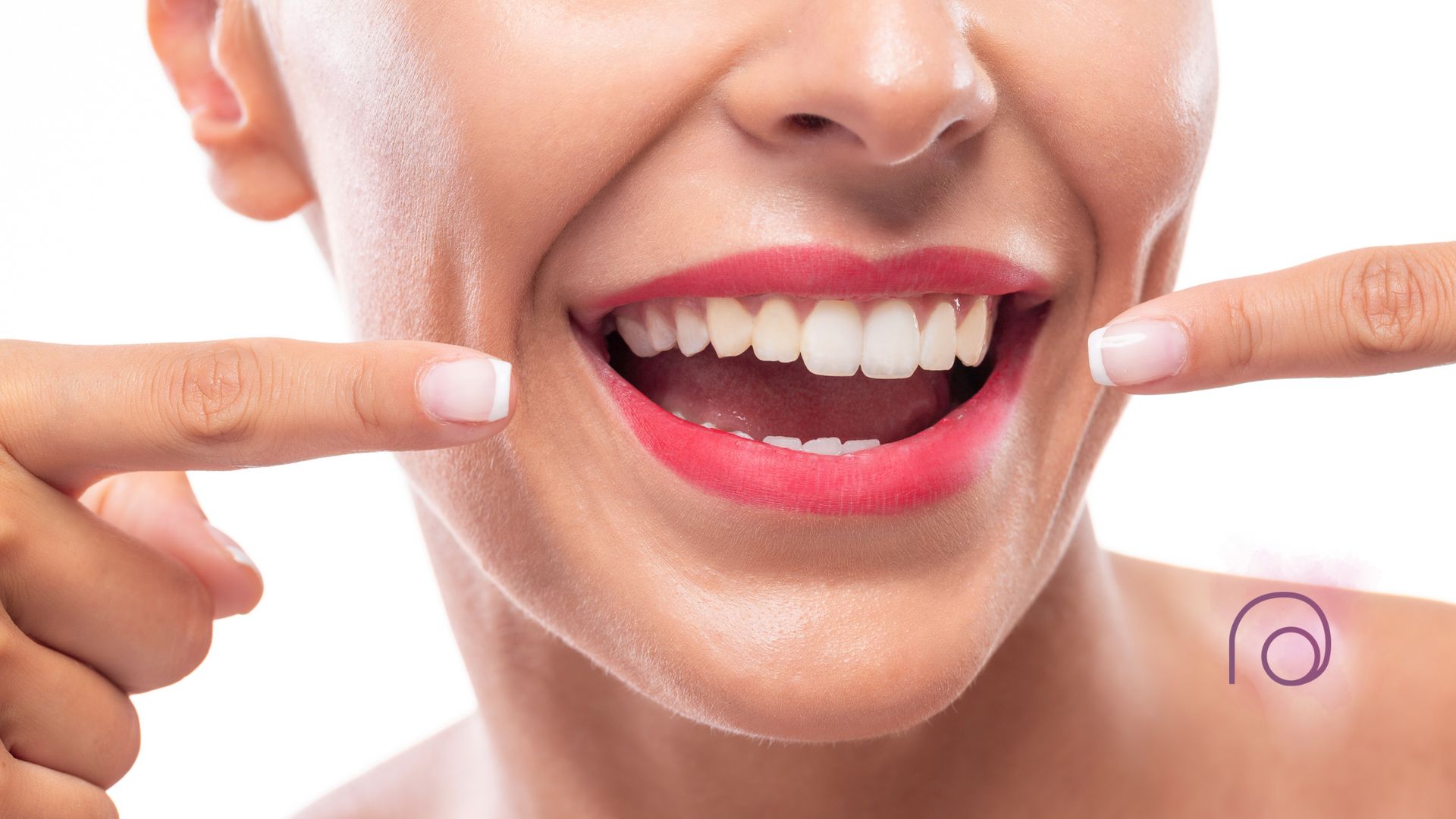 A woman is pointing at her teeth with her fingers.