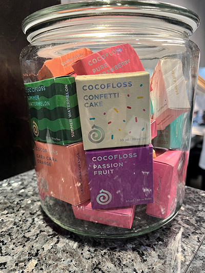 A glass jar filled with different flavors of coco floss.