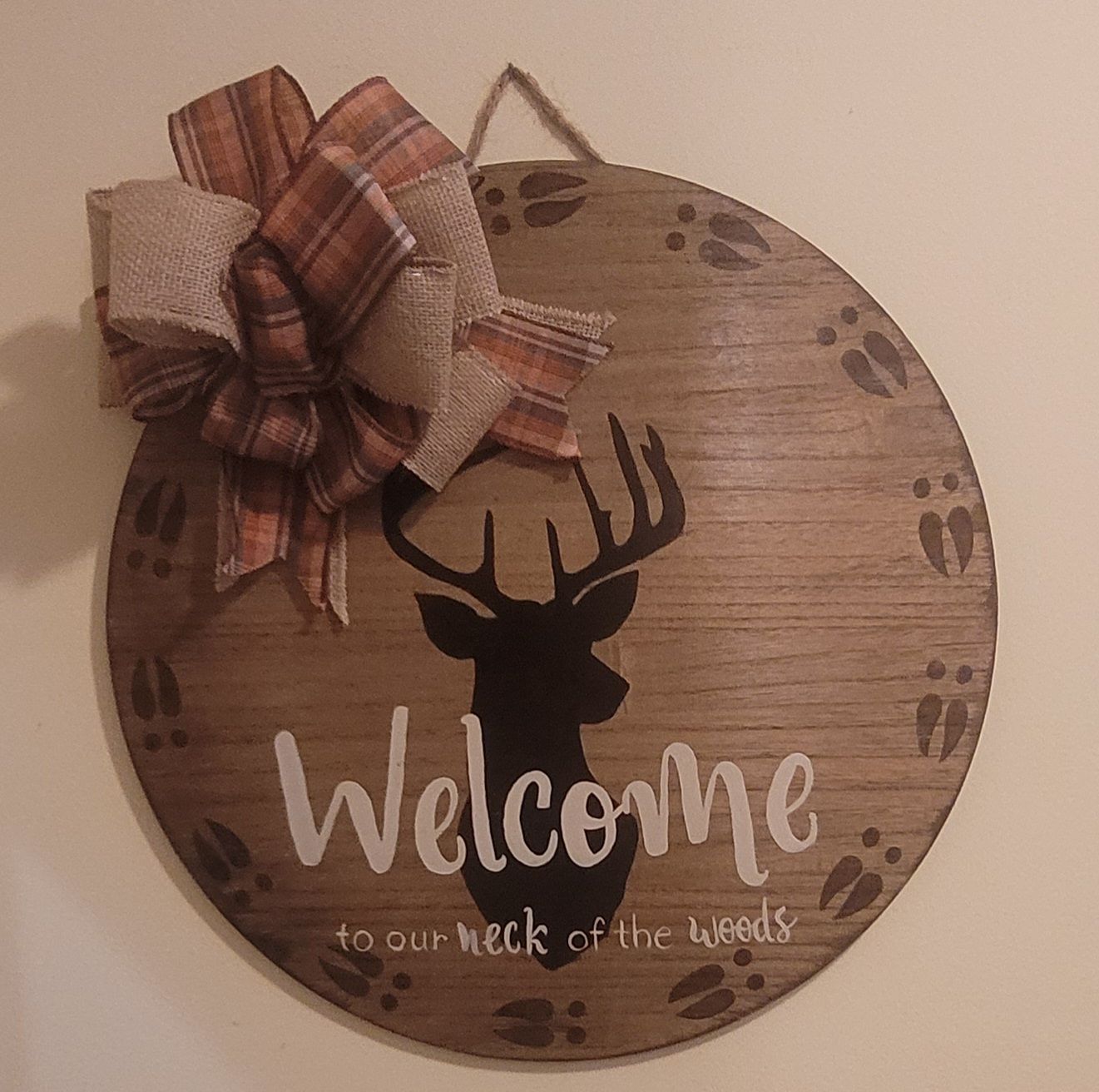 A wooden door sign with a deer and the words welcome to our neck of the woods