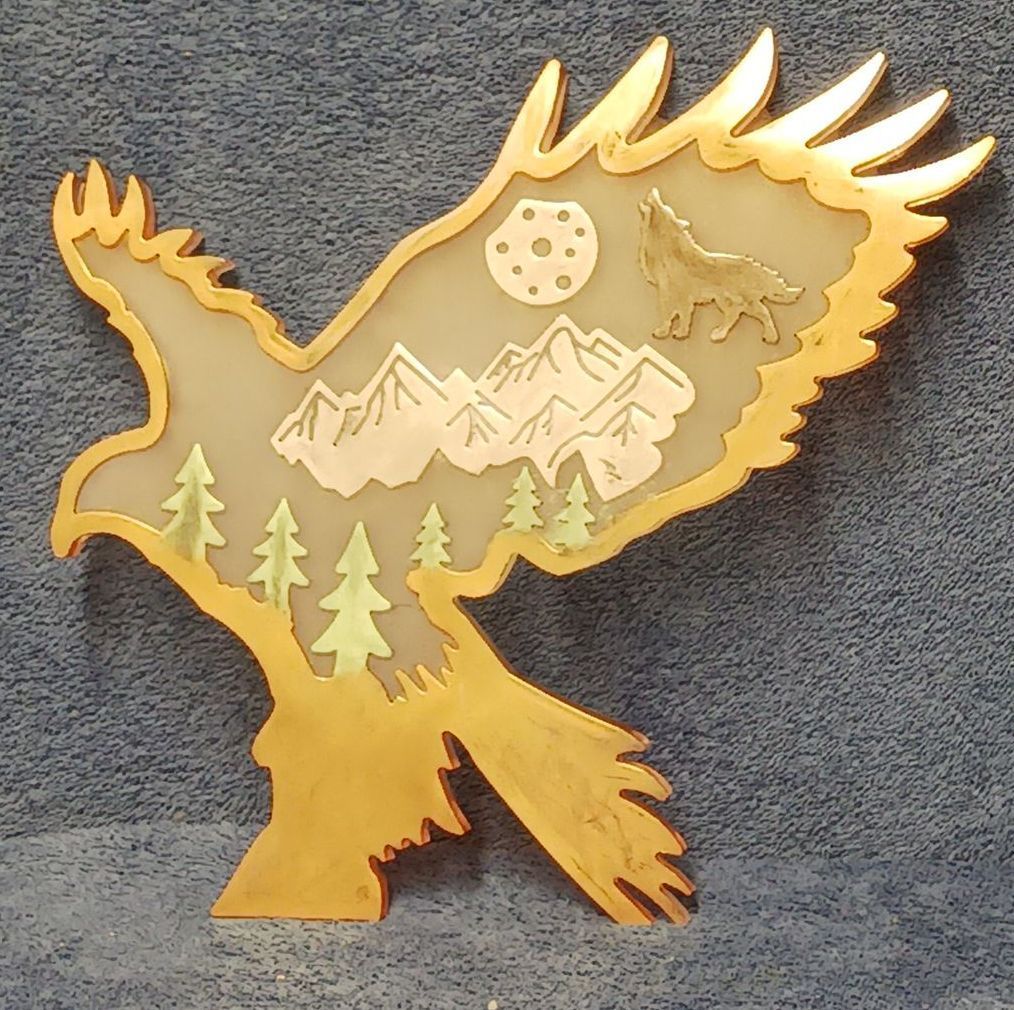 A resin wooden eagle with trees and mountains in the background