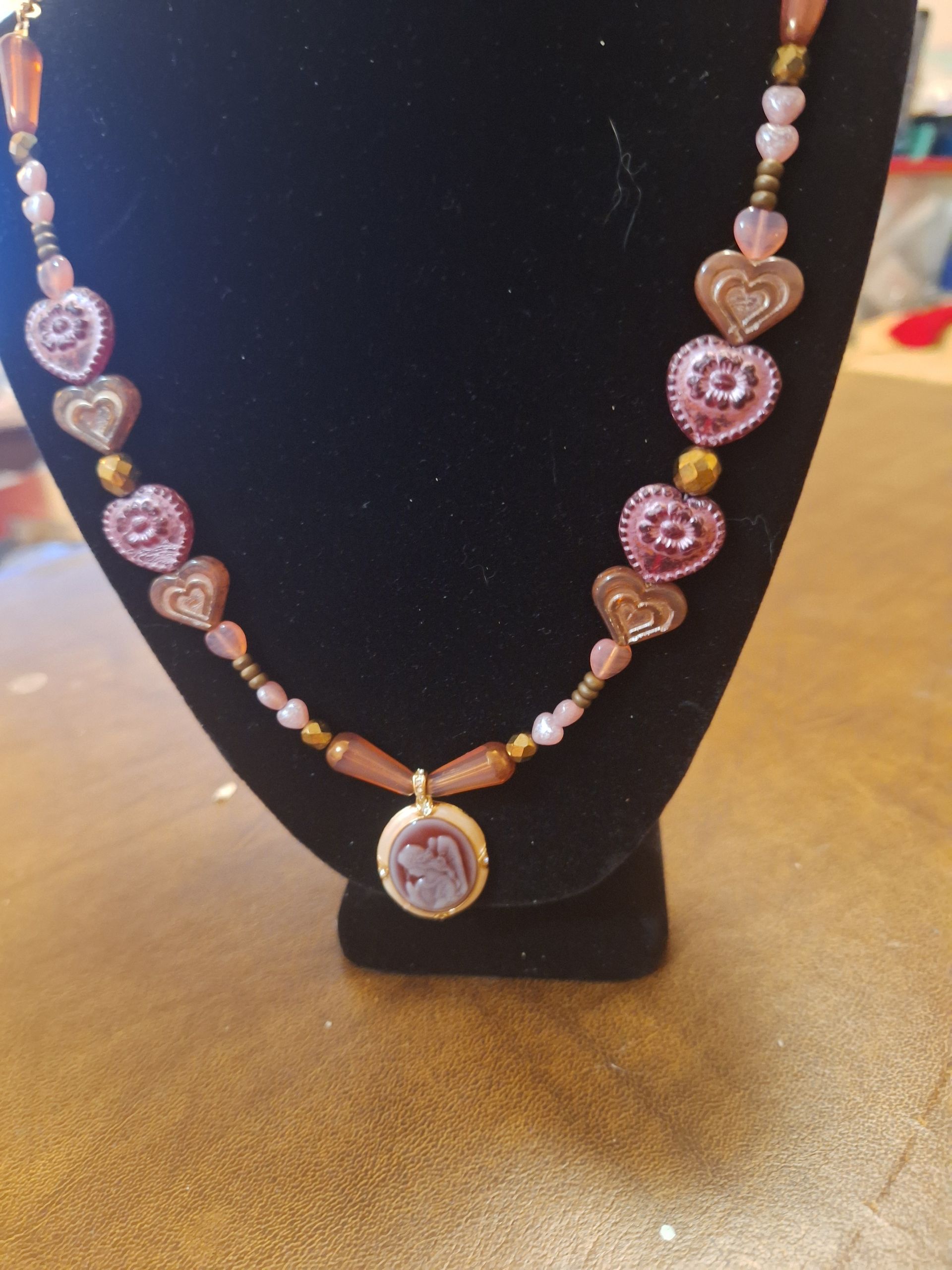 A necklace with hearts and beads is on a mannequin