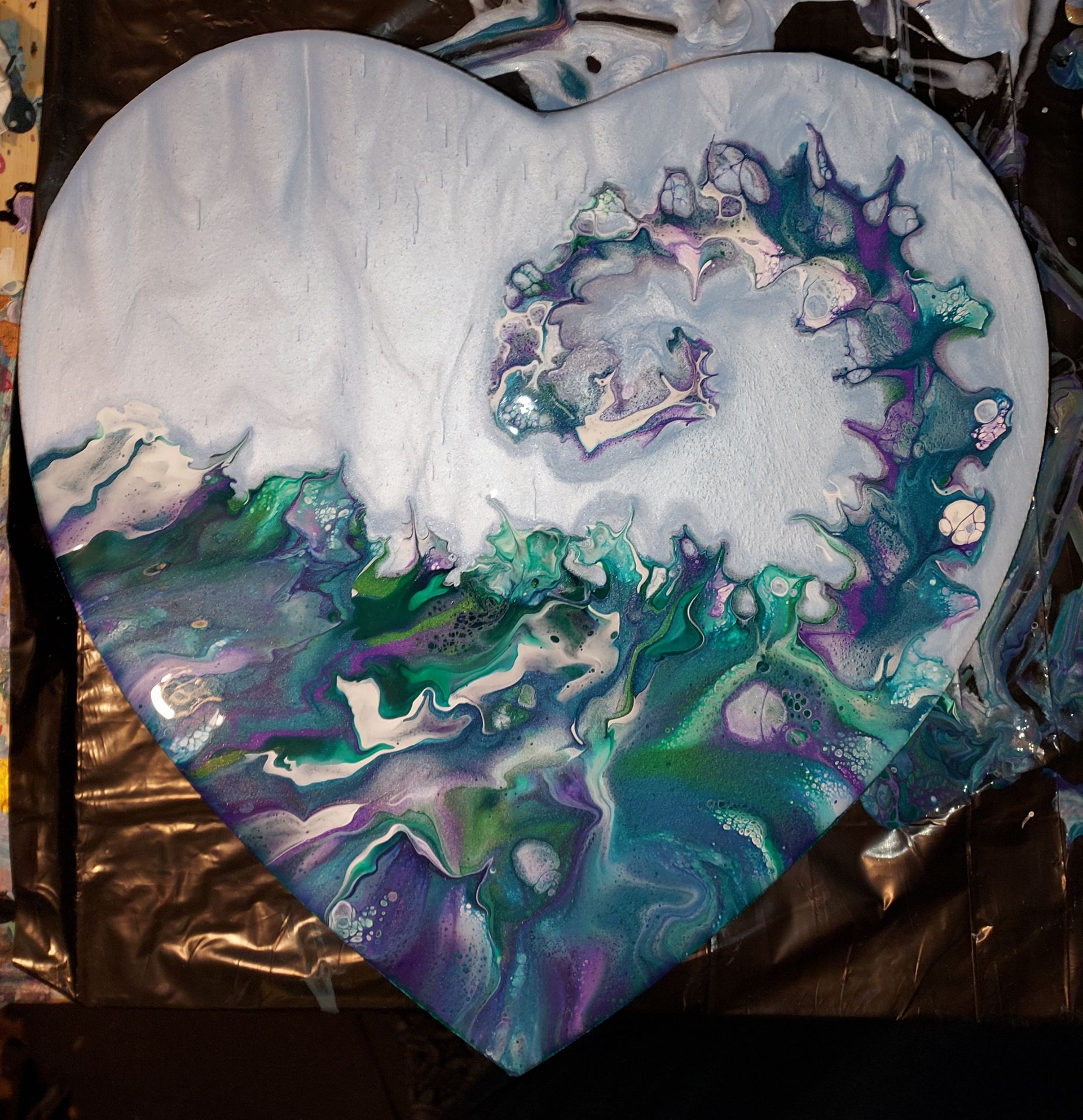 A painting in the shape of a heart is sitting on a table