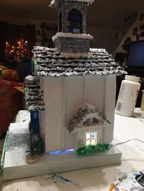 A model of a gingerbread house is sitting on top of a table.