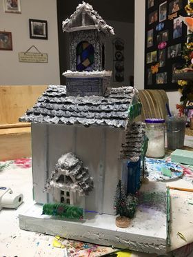 A model of a gingerbread house is sitting on top of a table.