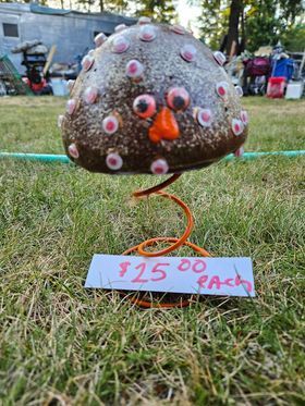 A handmade concrete decorative mushroom sitting on grass made by Cindy Harwood