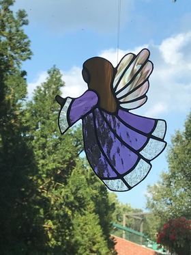 A stained glass angel is flying in the sky.