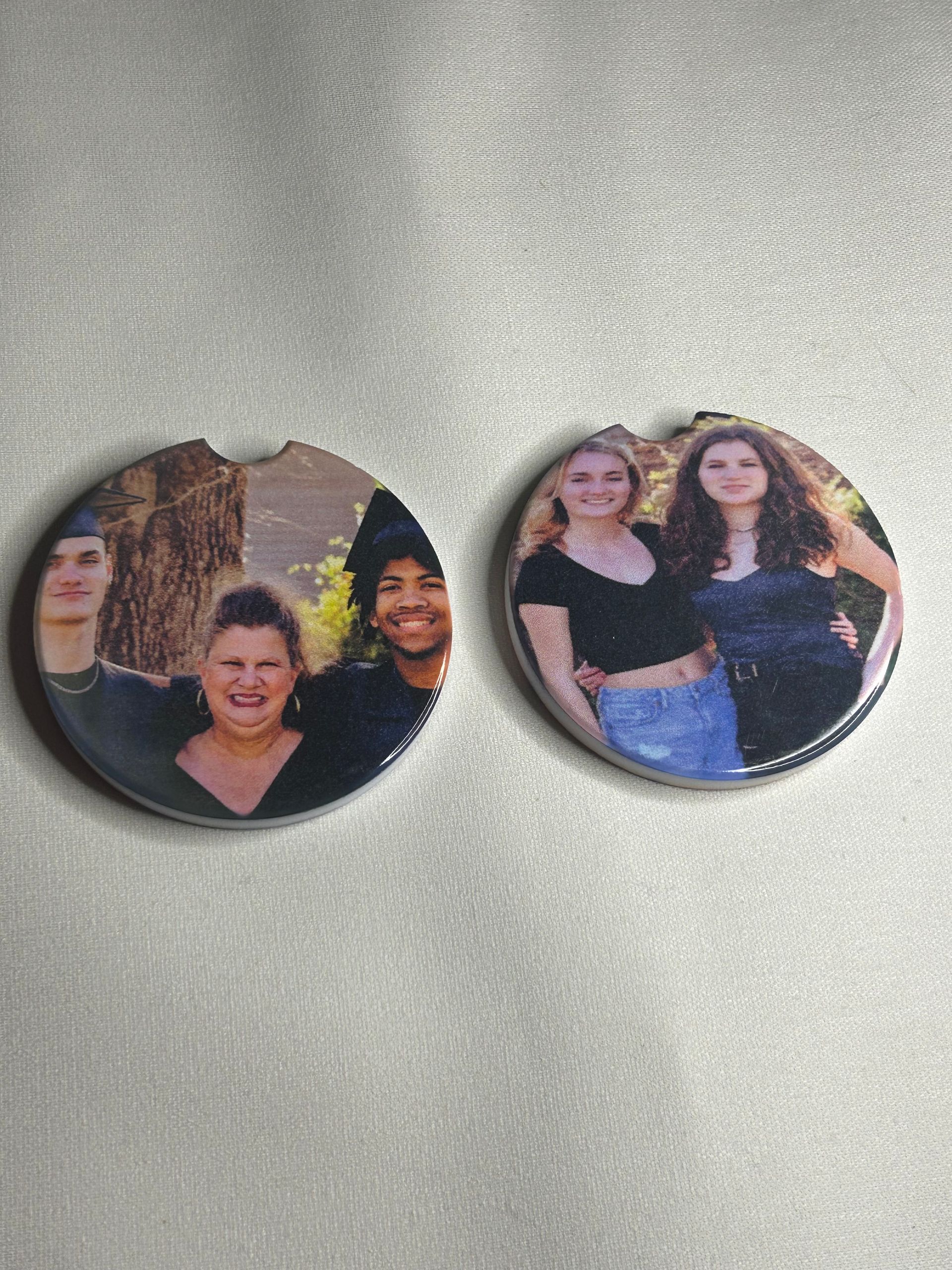 Two buttons with a picture of a group of people on them are sitting on a table.