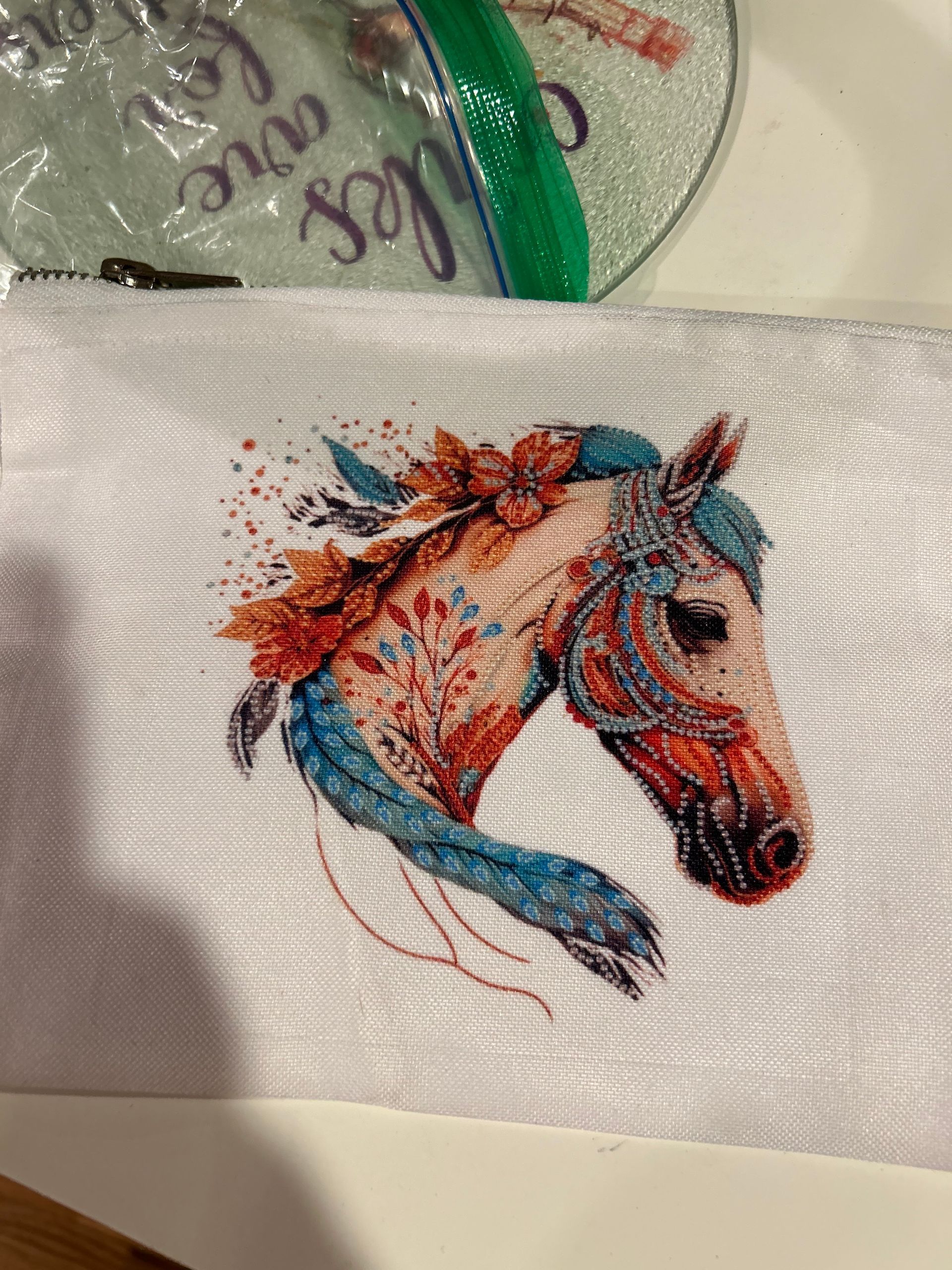 A cross stitch of a horse 's head with flowers on it