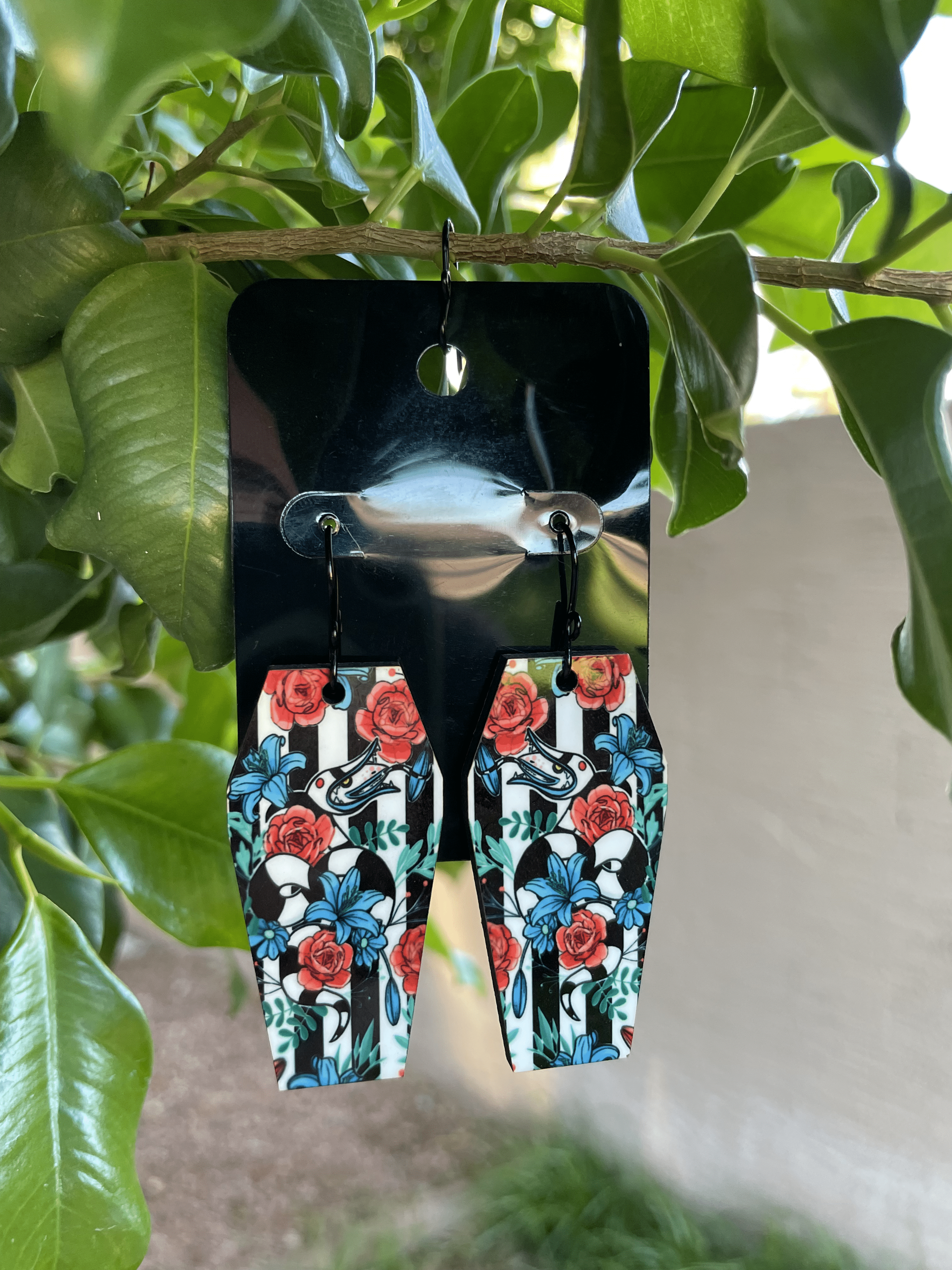 A pair of earrings hanging from a tree branch.