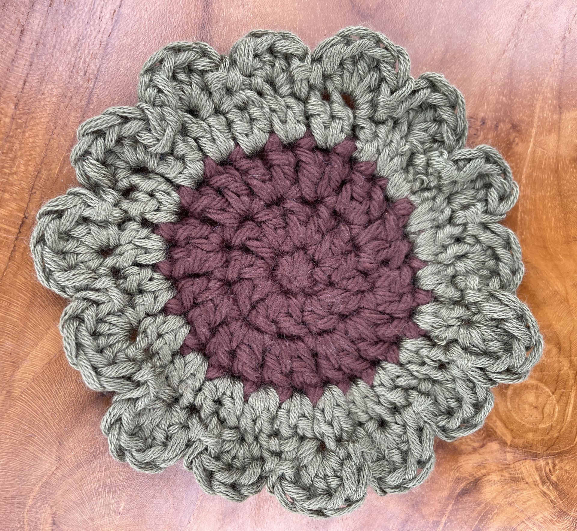 A close up of a crocheted flower on a blurry background.