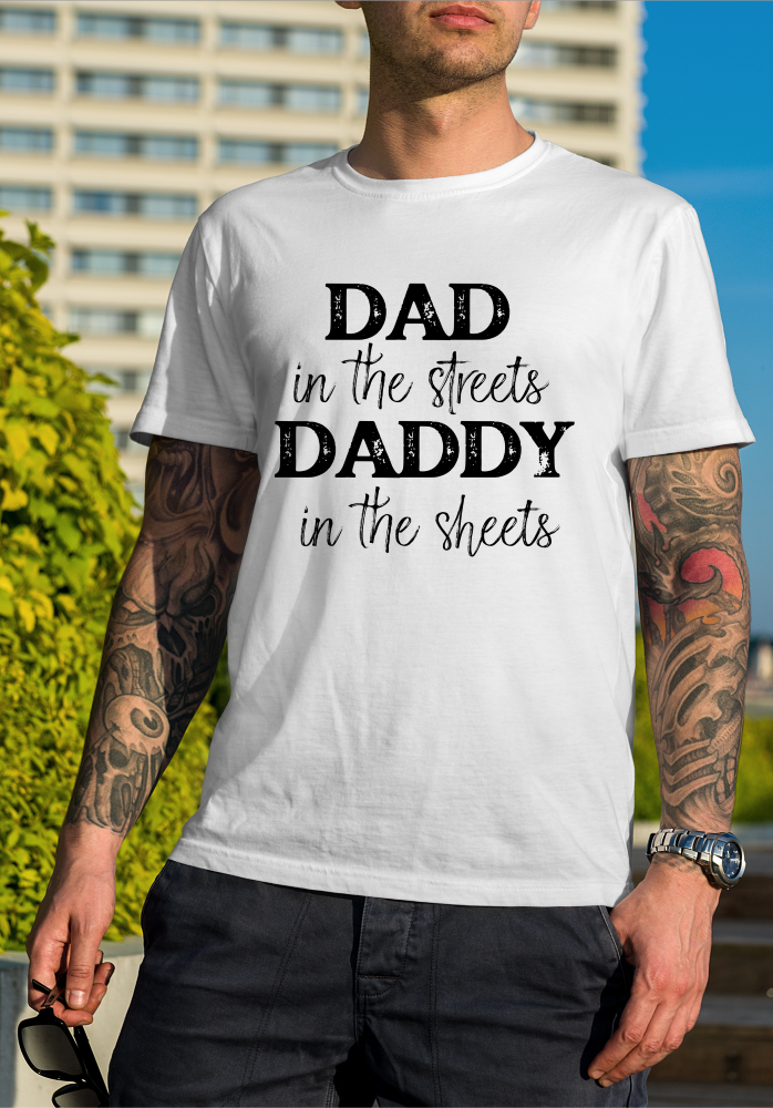 A man is wearing a white t-shirt that says `` dad in the streets daddy in the sheets ''.