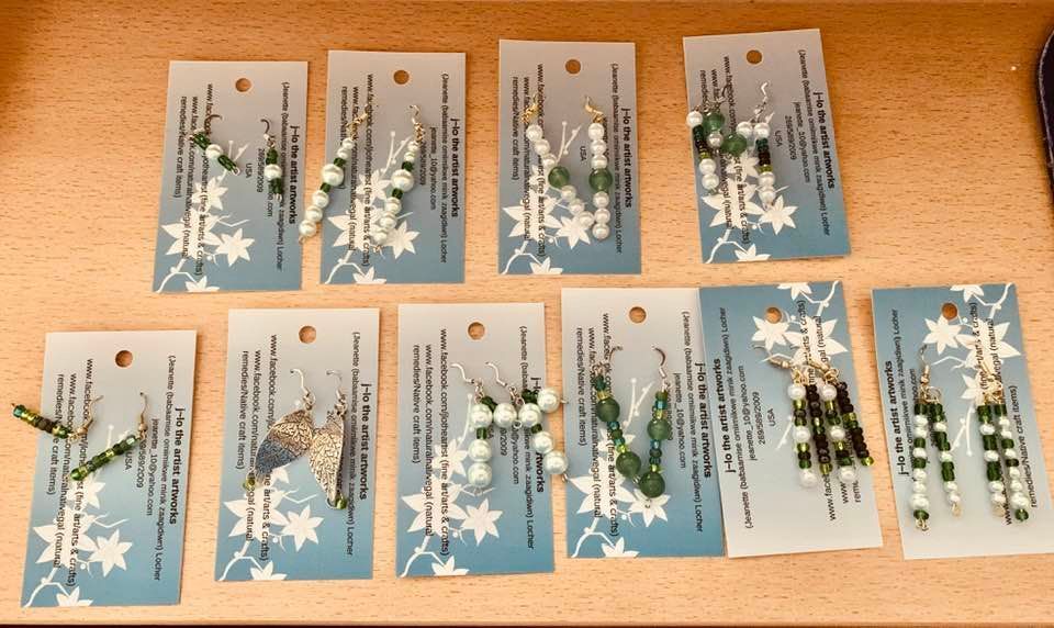A bunch of cards with earrings displayed on them on a table 