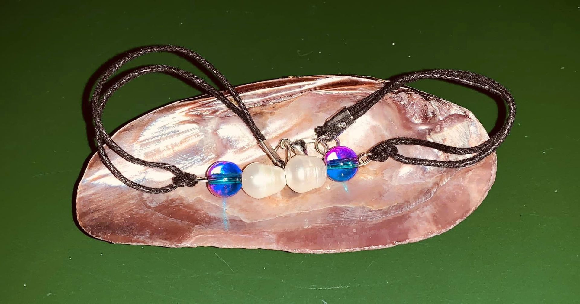 A bracelet with pearls and blue beads on a shell