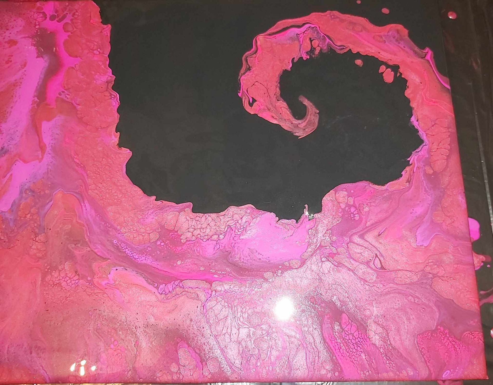 A pink and black painting with a spiral in the middle