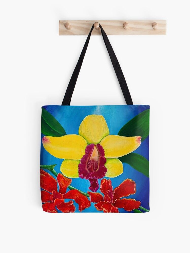A tote bag with a yellow flower and red flowers on it
